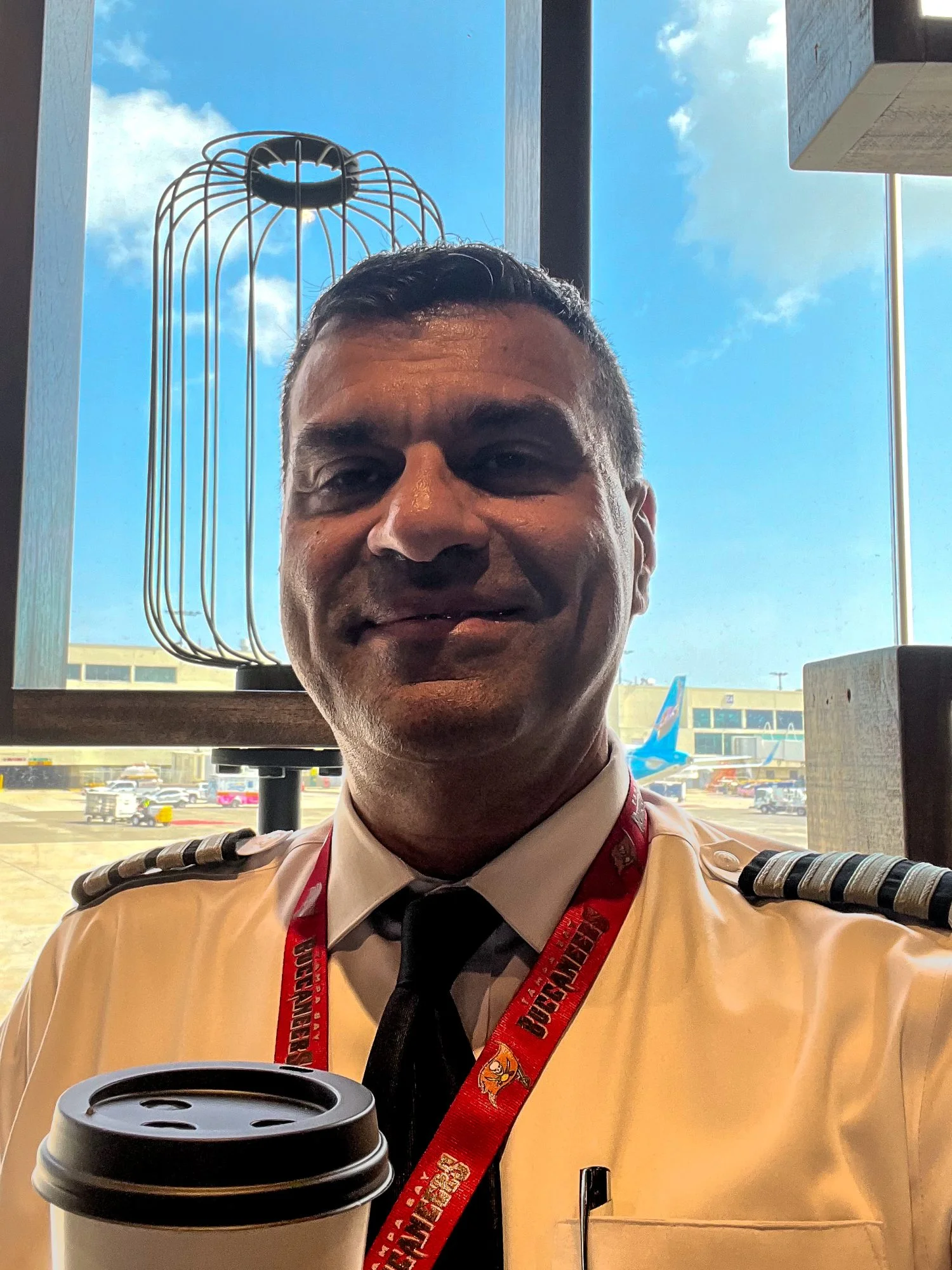 head and shoulders photo of an airline pilot captain, Omar Dahmash, with his morning to-go coffee